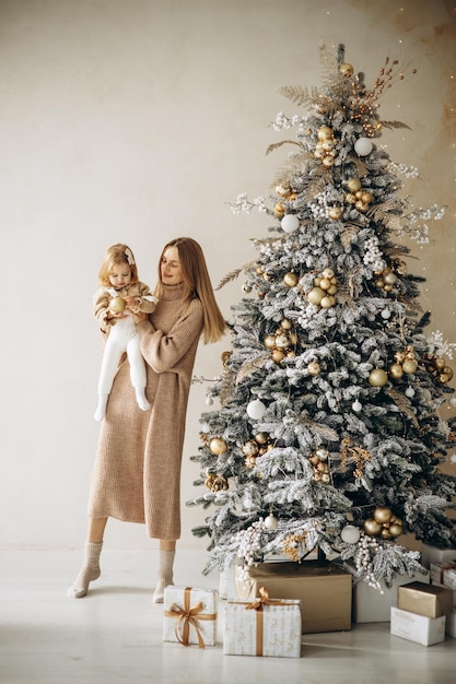 Mère avec sa petite fille près de l'arbre de Noël