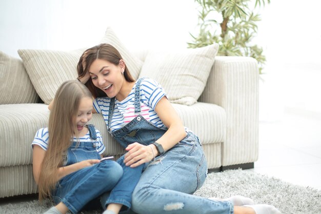 Mère et sa petite fille utilisent un smartphone pour voir la photophoto avec espace de copie