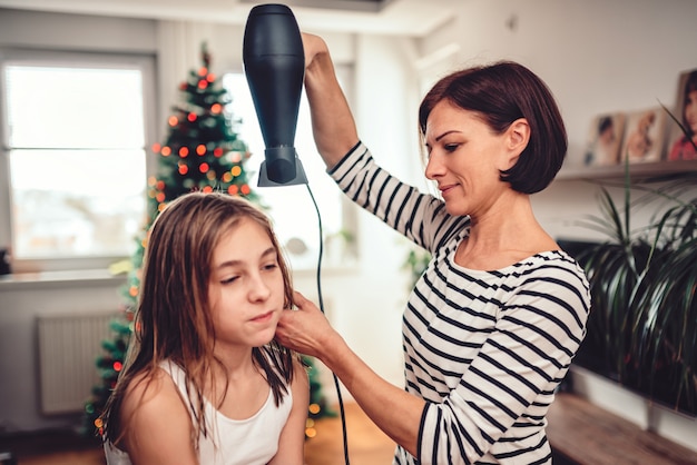 Mère séchant les cheveux à sa fille