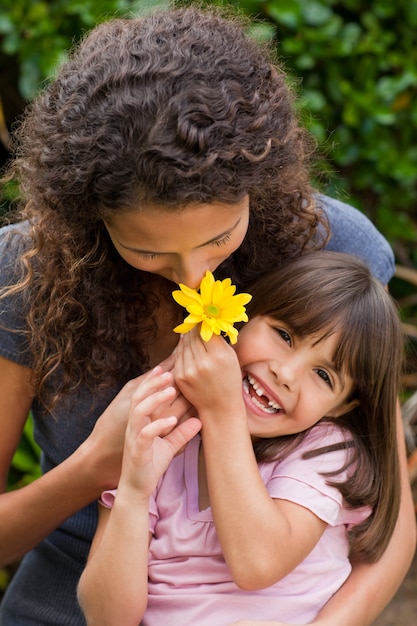 Mère sentant une fleur avec sa fille