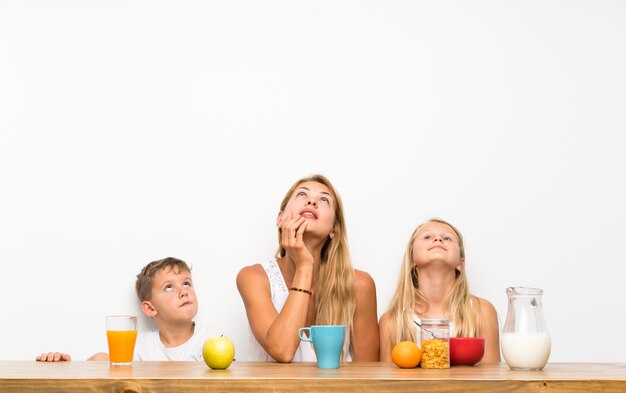 Mère avec ses deux enfants prenant son petit déjeuner en levant