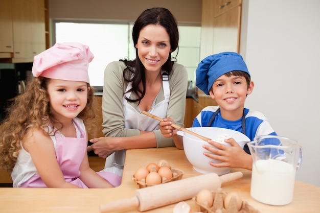 Mère et ses enfants préparent le gâteau