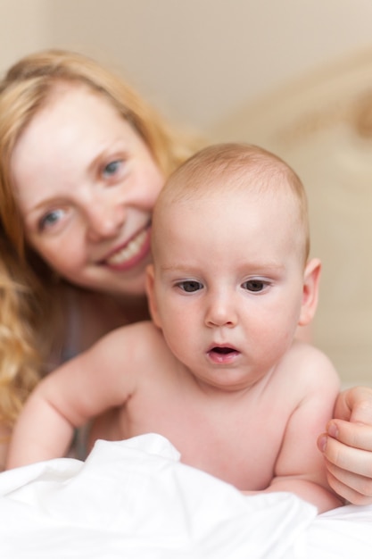 Mère avec son bébé jouant sur le lit