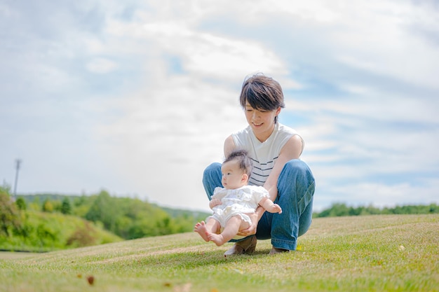 Une mère et son bébé jouent dans l'herbe.