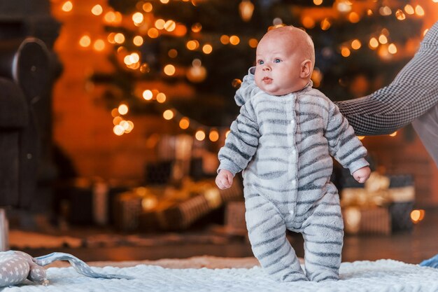 Mère avec son enfant ensemble dans la chambre décorée de Noël.