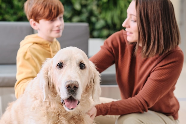 Mère et son fils aimant et prenant soin de leur beau labrador