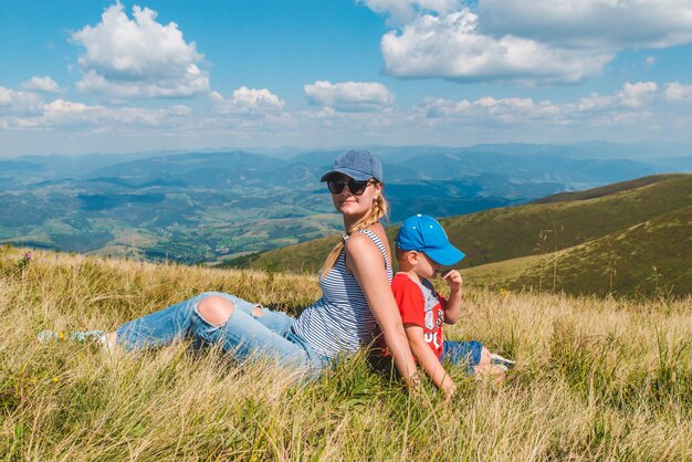 mère avec son fils au sommet de la montagne belle vue sur le paysage