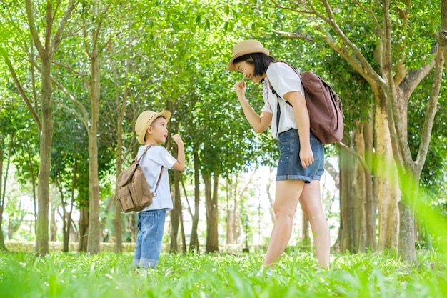 Une mère et son fils jouent dans les champs d&#39;herbe en plein air le soir