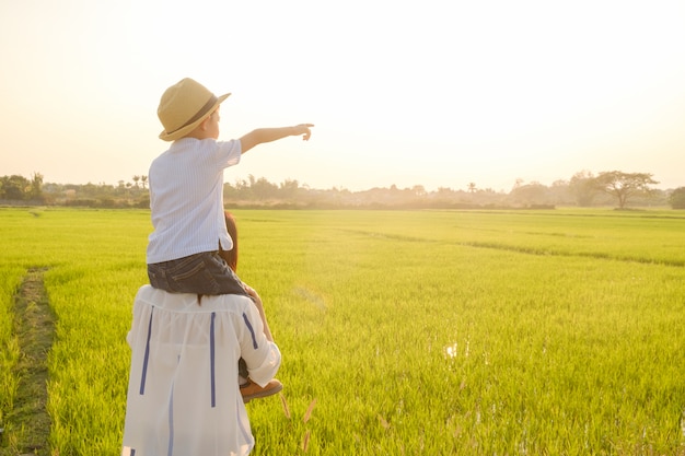 Une mère et son fils jouent à l&#39;extérieur au coucher du soleil