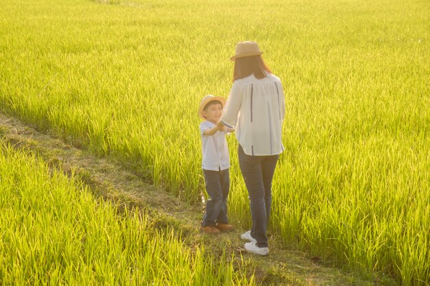 Une mère et son fils marchant en plein air au coucher du soleil