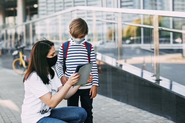 Mère et son fils portant des masques de protection à l'extérieur