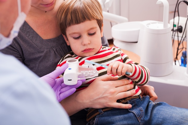 Photo mère et son fils à la réception chez le dentiste