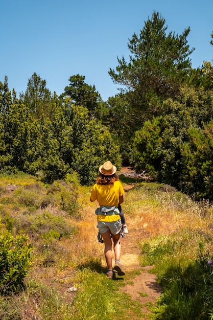 Une mère avec son fils tenant son fils dans ses bras sur le sentier de randonnée La Llania à El Hierro Îles Canaries