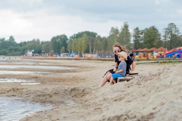 Photo une mère et son mignon petit fils profitent du temps à la plage.