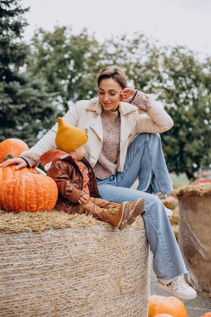 Mère avec son petit fils par les citrouilles à l'halloween