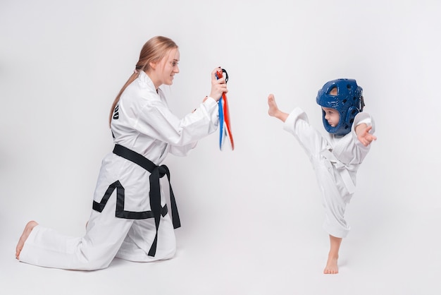 Mère son petit fils pratiquant les arts martiaux sur blanc