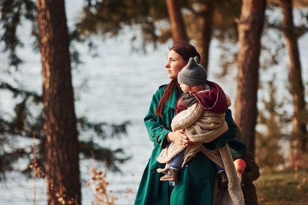 Mère avec son petit fils se promener dans la forêt de printemps pendant la journée