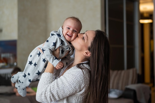 Une mère souriante embrassant un garçon à la maison