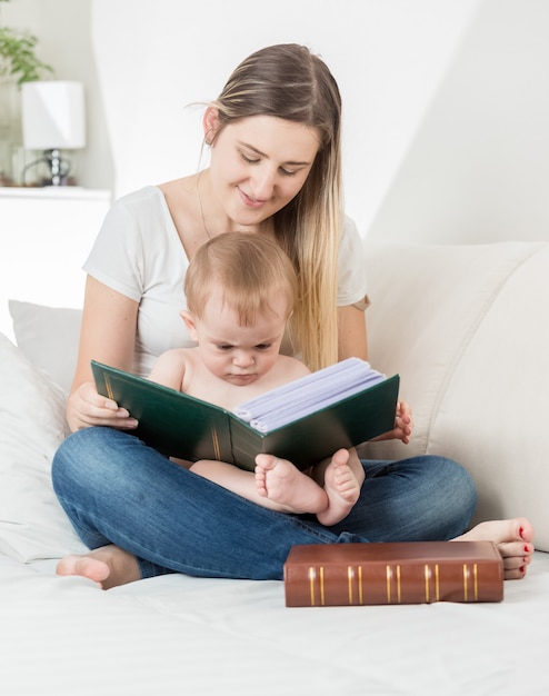 Mère souriante lisant une histoire à son petit garçon de 9 mois