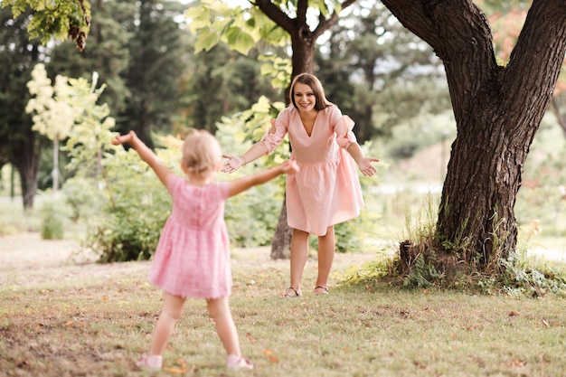 Mère souriante s'amusant avec sa petite fille à l'extérieur se regardant Maternité Maternité