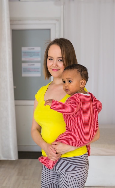 Mère souriante avec son bébé métis à la maison.