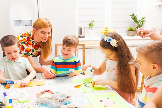 La mère sourit en regardant la carte de voeux de son fils faite avec ses mains