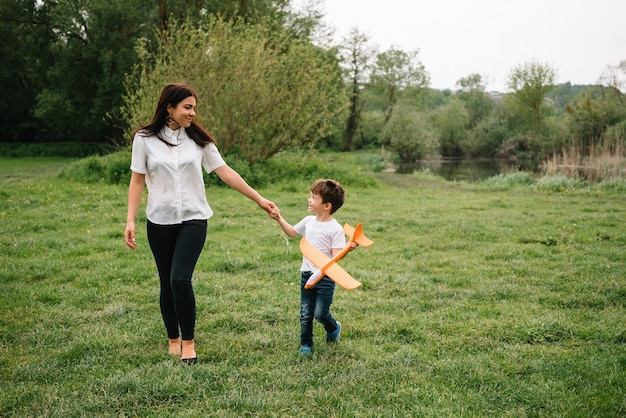 Mère Stilish et beau fils s'amusant sur la nature. Concept de famille heureuse.