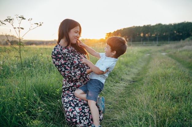 Mère Stilish et beau fils s'amusant sur la nature.