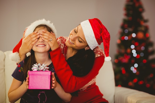 Mère surprenant sa fille avec un cadeau de Noël