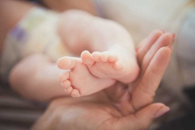 La mère tenait les pieds de bébé dans sa main