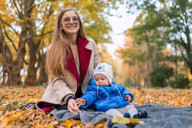 Mère tenant bébé dans les bras dans le parc