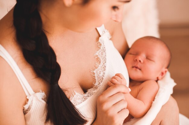 Mère tenant un bébé sur les mains dans la chambre Bonjour Maternité Maternité Focus sur les mains