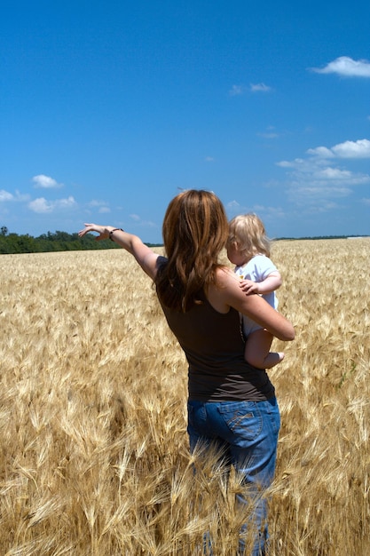 Mère tenant un enfant au champ de blé