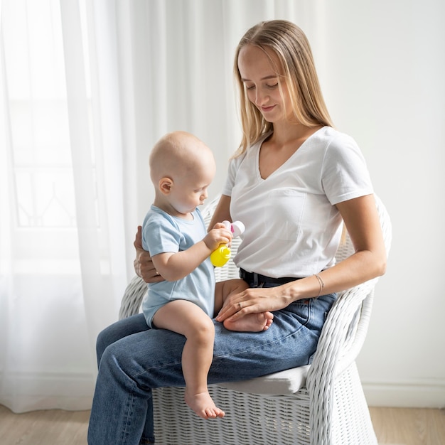 Mère tenant l'enfant à la maison pendant la quarantaine