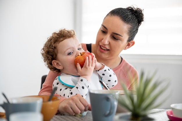 Mère tenant l'enfant en mangeant