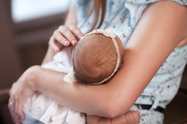 Mère tenant la tête de son fils nouveau-né dans les mains Le bébé sur les mains de maman