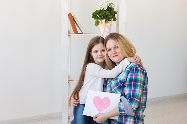 Mère tient la carte de voeux de sa jolie fille