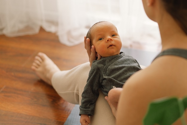 Photo la mère tient et embrasse son bébé nouveau-né à la maison bébé heureux et maman