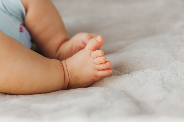 La mère tient les jambes du nouveau-né. pieds de bébé se bouchent