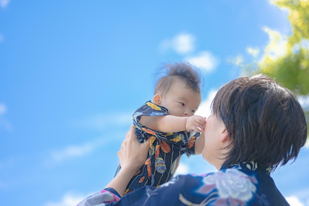 Une mère tient son bébé en l'air.