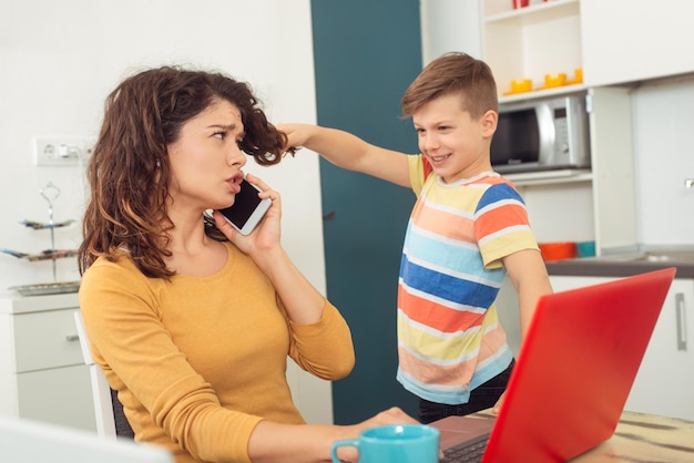 Photo mère travaillant à domicile avec enfant quarantaine et école maternelle fermée pendant l'épidémie de coronavirus