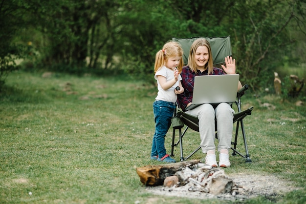 Mère travaille sur Internet avec enfant à l'extérieur