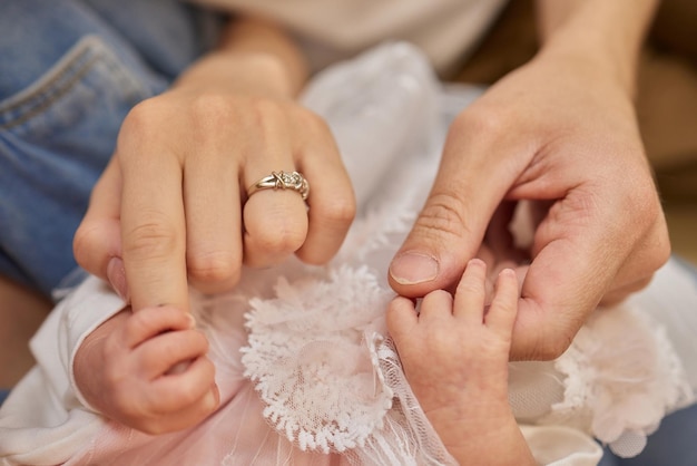 La mère utilise sa main pour tenir la petite main de son bébé pour lui faire sentir son amour chaleureux et en sécurité