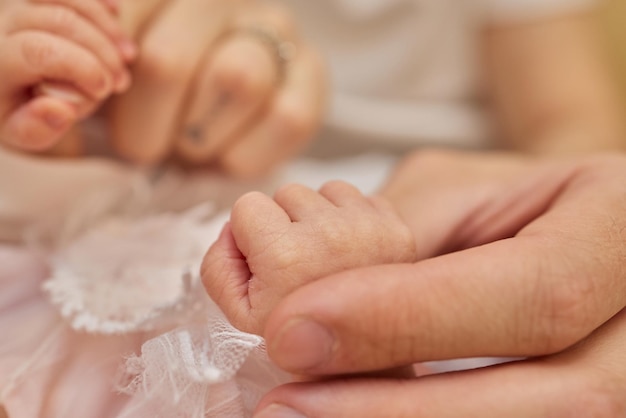 La mère utilise sa main pour tenir la petite main de son bébé pour lui faire sentir son amour chaleureux et en sécurité