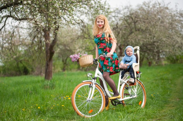 Mère à vélo avec bébé dans une chaise de vélo