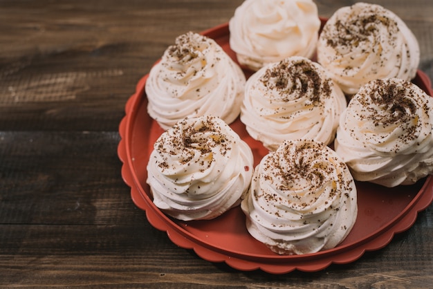 Photo meringue pavlova couleur crème sur un plateau rouge