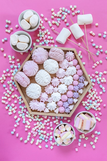 Photo meringue et variété de planche de charcuterie de guimauves sur fond rose. gros plan, vue de dessus.