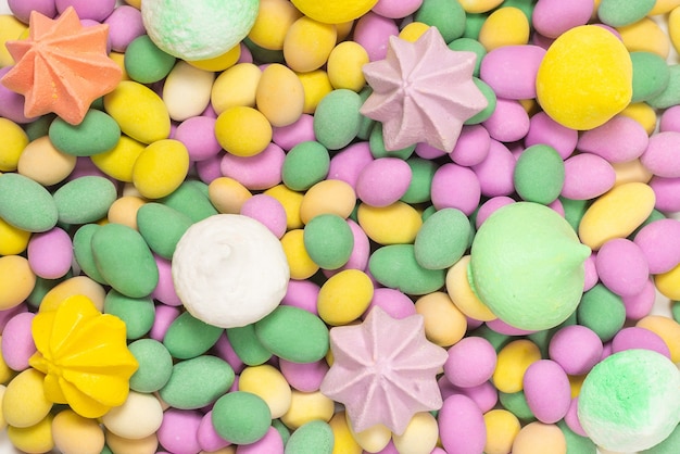 Meringues colorées et cacahuètes glacées isolés sur fond blanc. Vue de dessus.