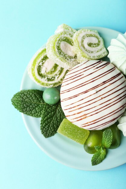 Meringues de couleur menthe, bonbons à la menthe et gâteau savoureux sur fond de couleur