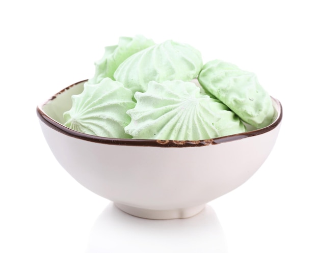 Meringues de couleur menthe dans un bol isolé sur blanc